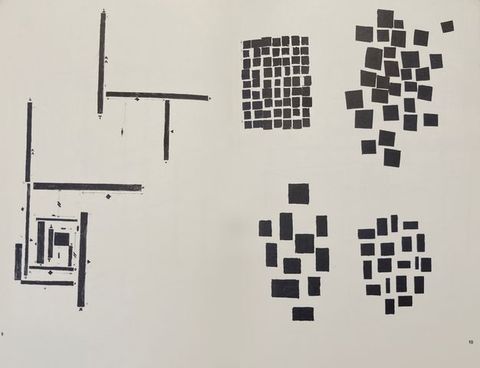 Black and white photograph. A white background is decorated with a series of simple, geometric patterns featuring lines, rectangles and squares.